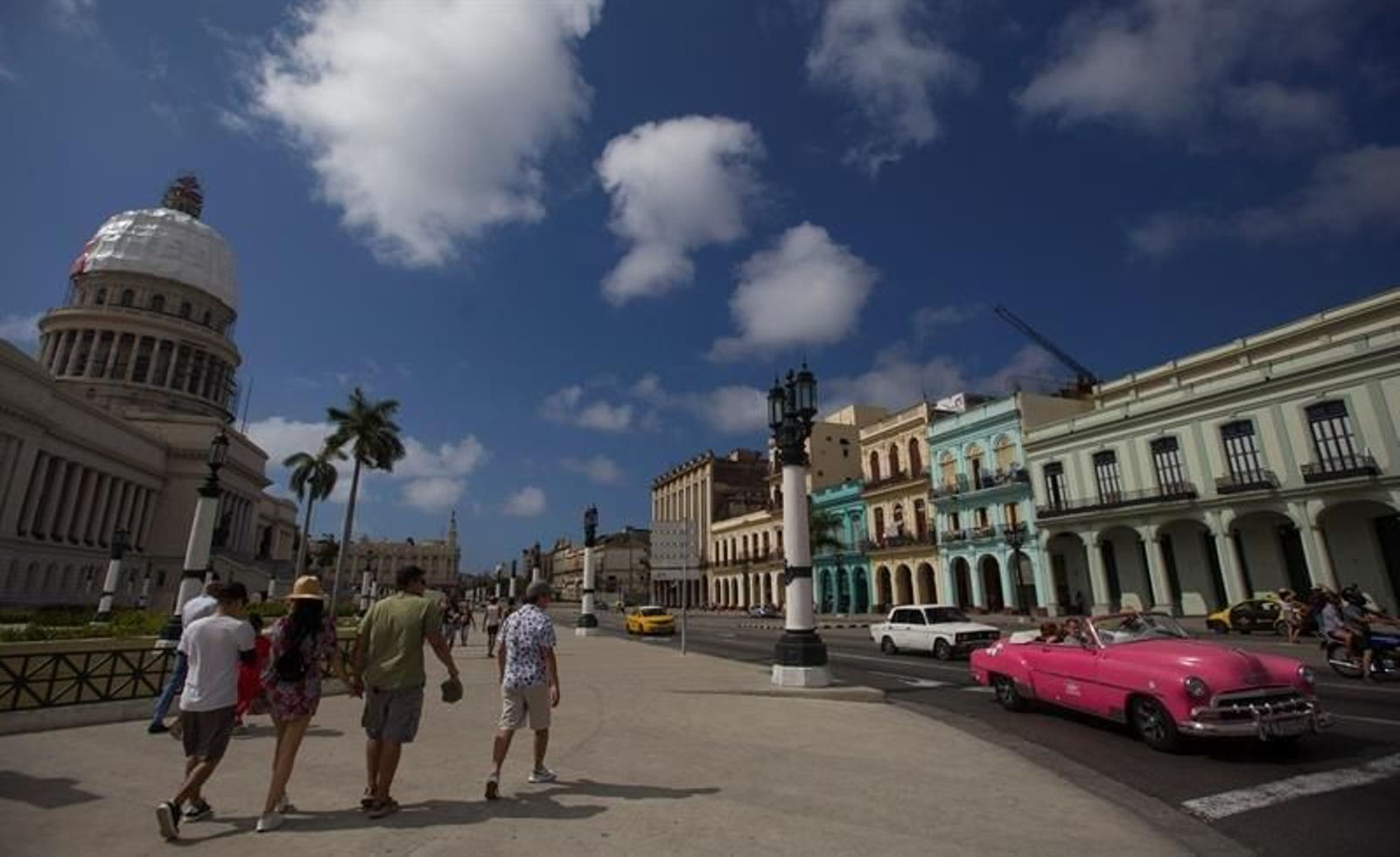 Varias personas y autos transitan cerca del Capitolio en La Habana