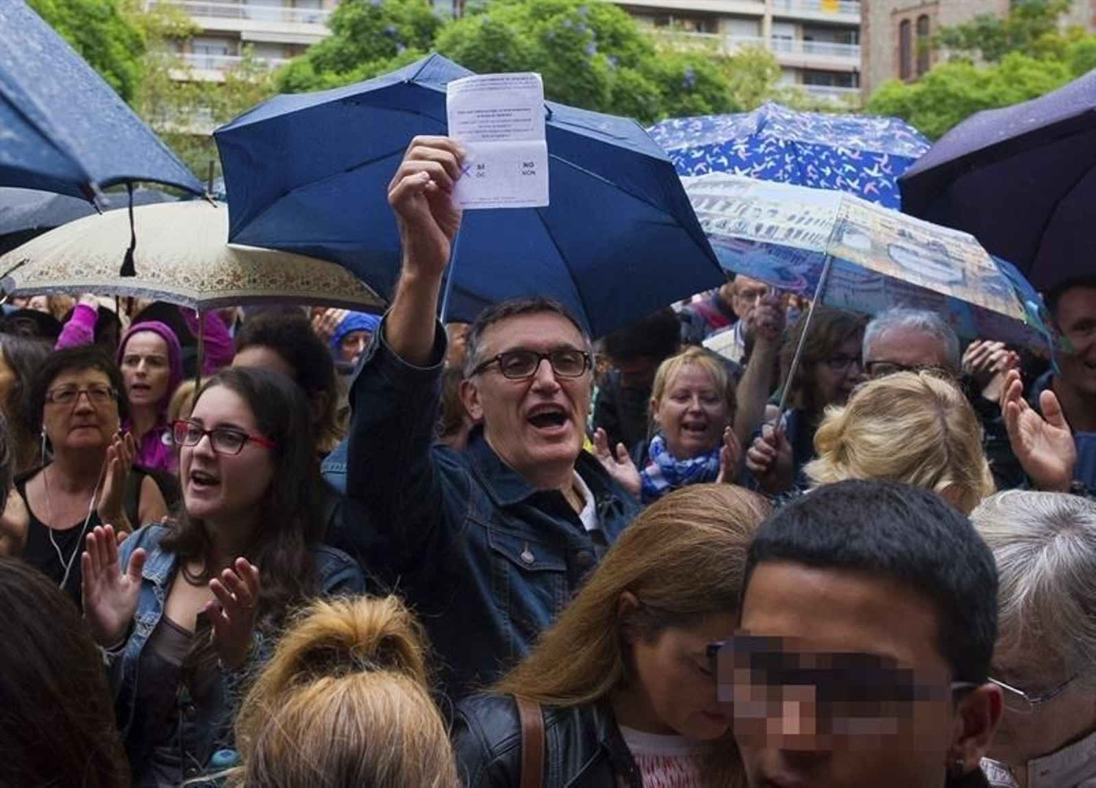 Un hombre muestra su papeleta para el referéndum independentisa del 1-O en Cataluña suspendido por el TC, mientras espera para votar en el IES Escola Industrial de Sabadell