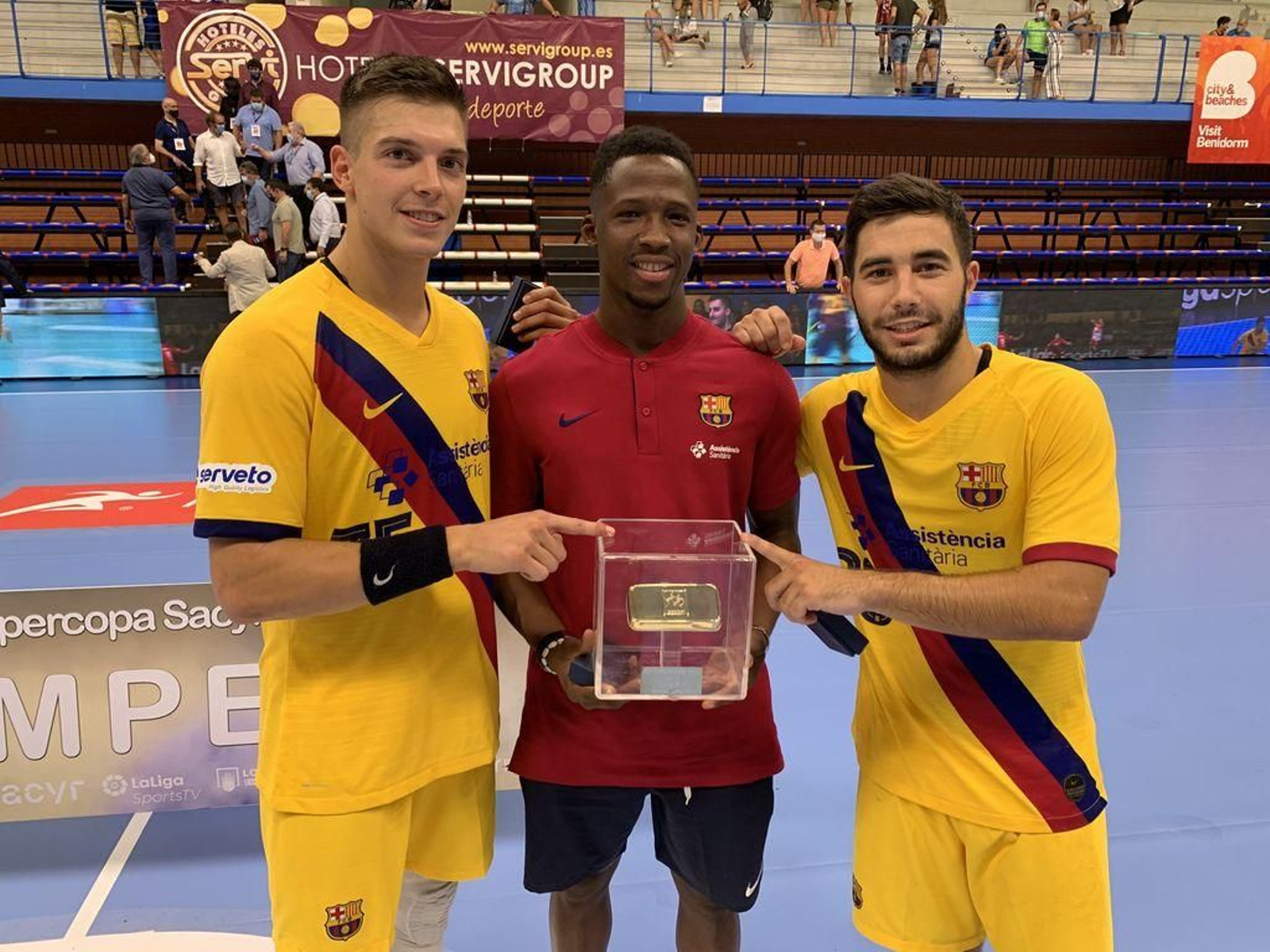 El olívico Álex Pascual (d.) posa con el trofeo junto a dos compañeros.