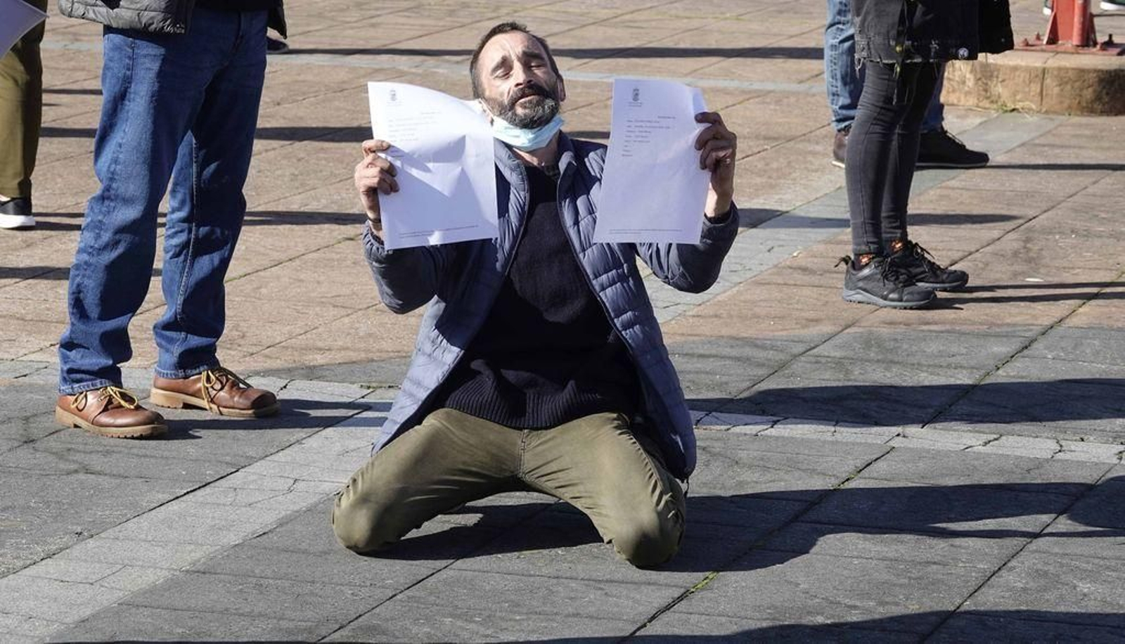 Javier, ayer, se arrodilla ante el Concello, antes de ser recibido por la asistente social.