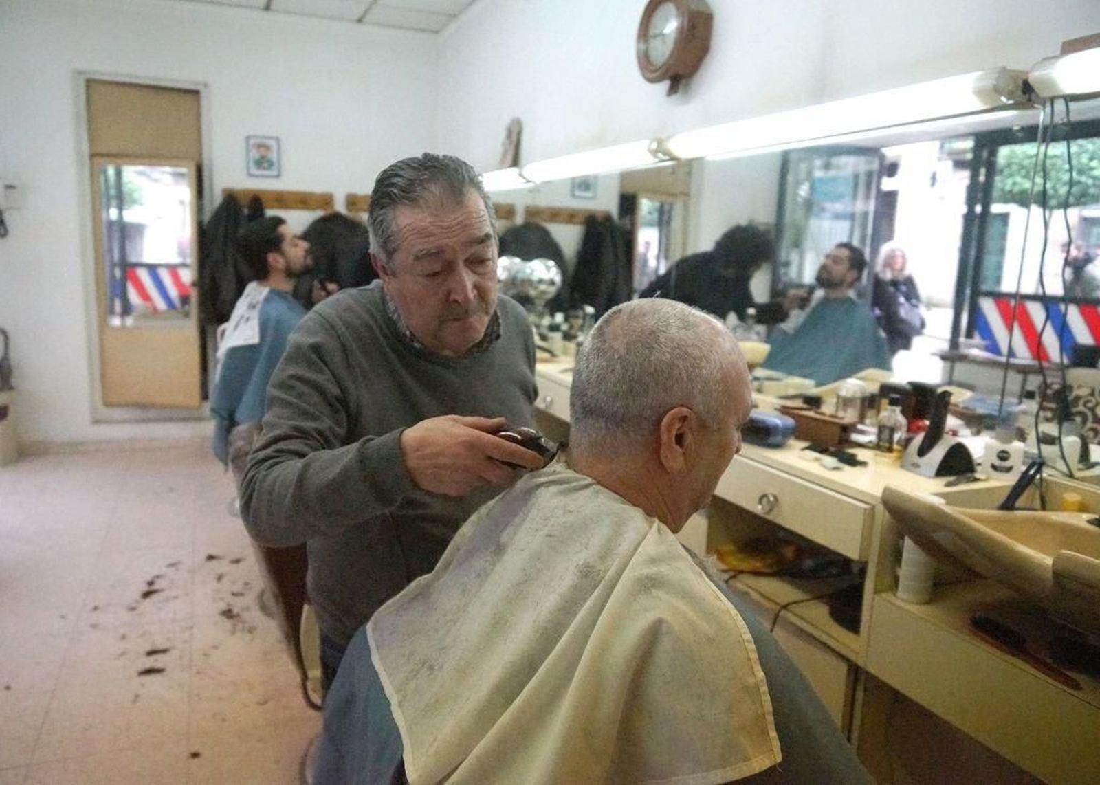 Pedro Fernández y su hijo Iago realizaron los últimos cortes a sus clientes en la calle Carral.
