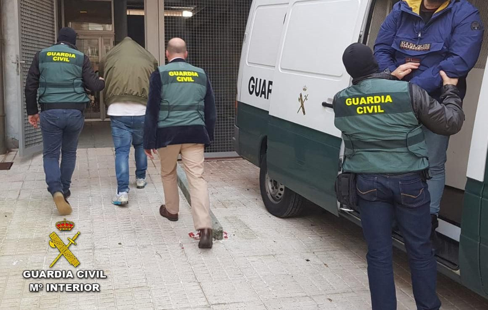 Agentes de la Guardia Civil trasladan al juzgado a los detenidos por el secuestro en Sanxenxo.