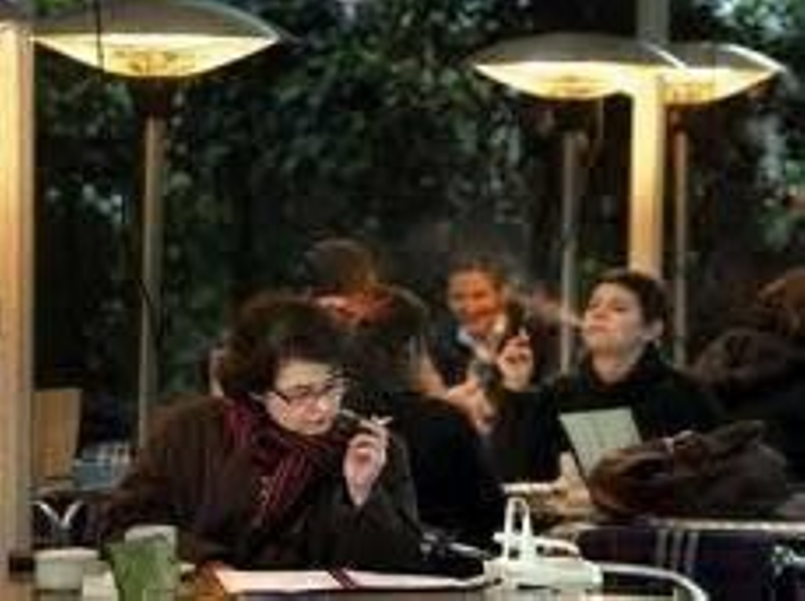 Un grupo de fumadores en una terraza.