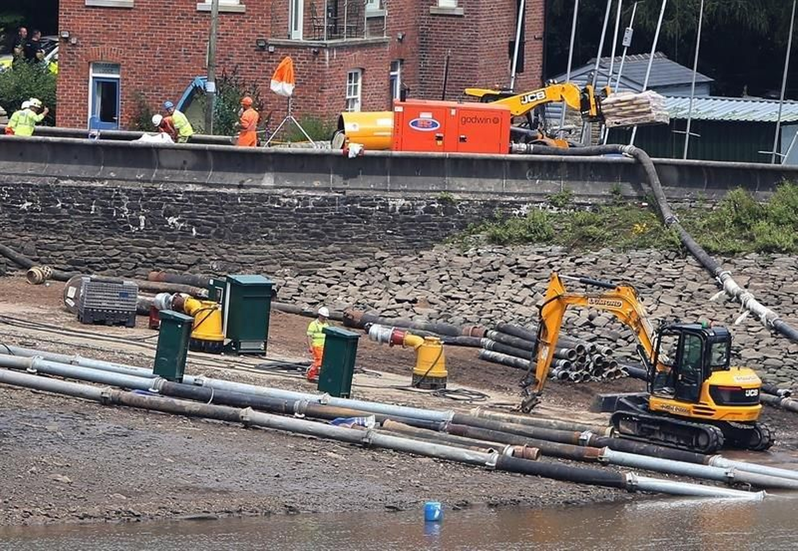 Los ingenieros y miembros de los servicios de emergencia trabajan para bombear agua desde el embalse de Toddbrook