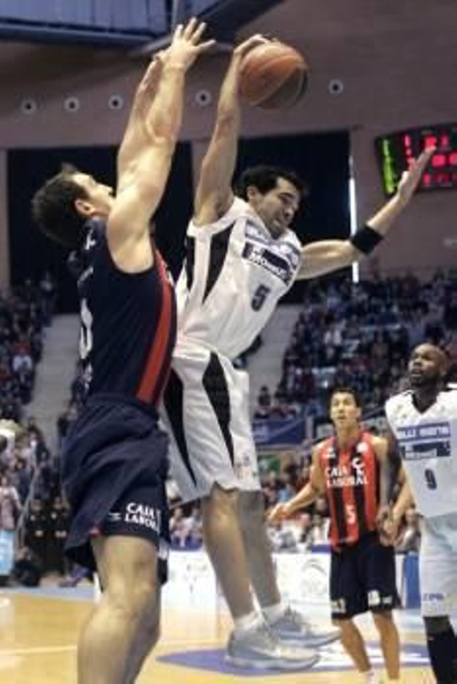 El pivot montenegrino del Caja Laboral, Vladimir Golubovic (i) lucha por un rebote con el base puertorriqueño Andrés Rodríguez (Foto: EFE)