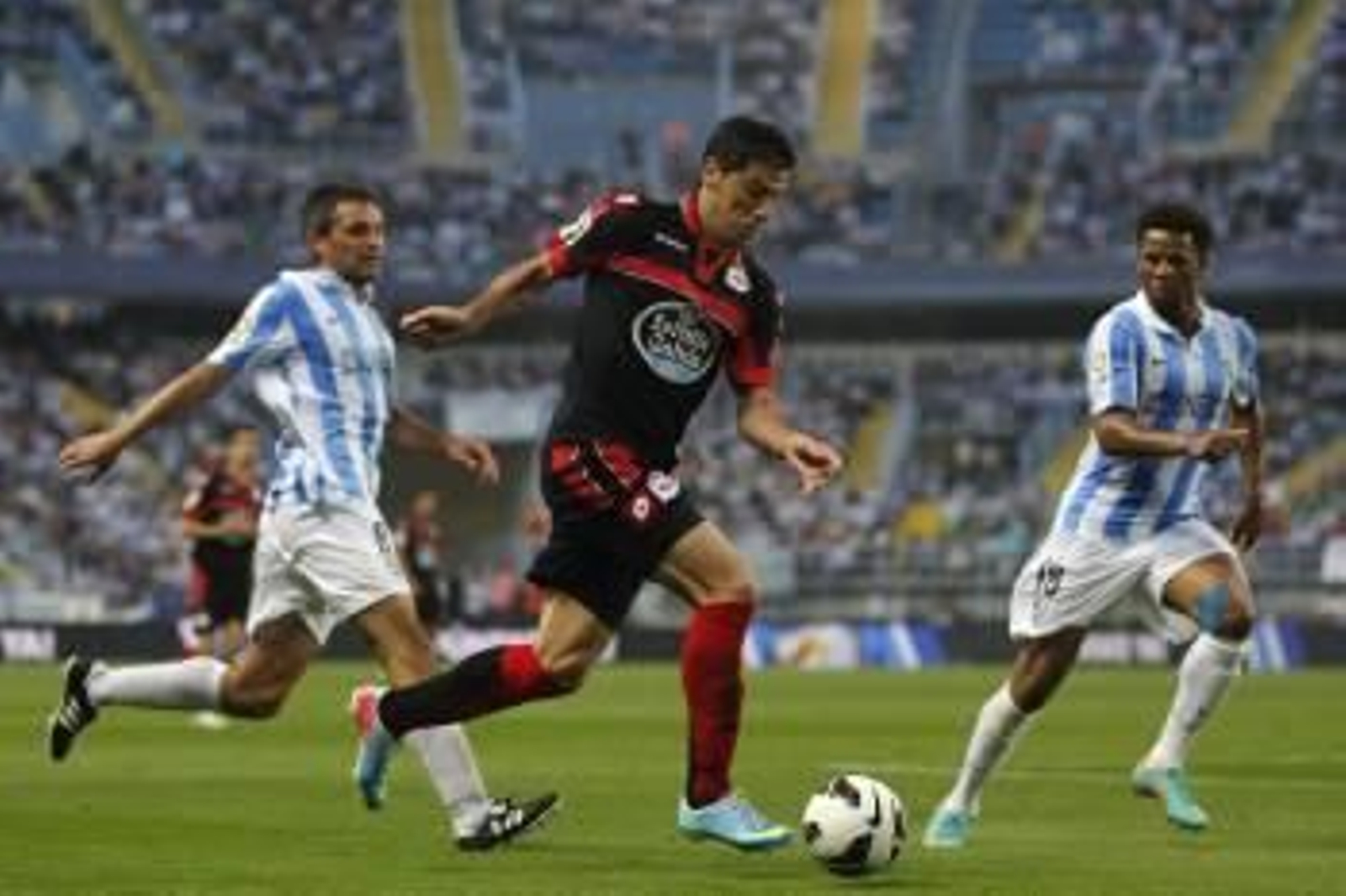 Riki controla el balón ante el centrocampista francés del Málaga Jérémy Toulalan. (Foto: JORGE ZAPATA)