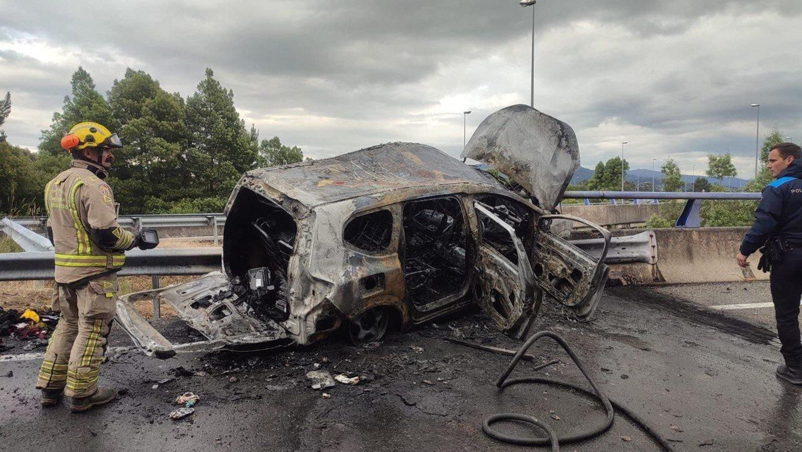 El coche calcinado por completo en la AP-9 tras arder. // Alberte