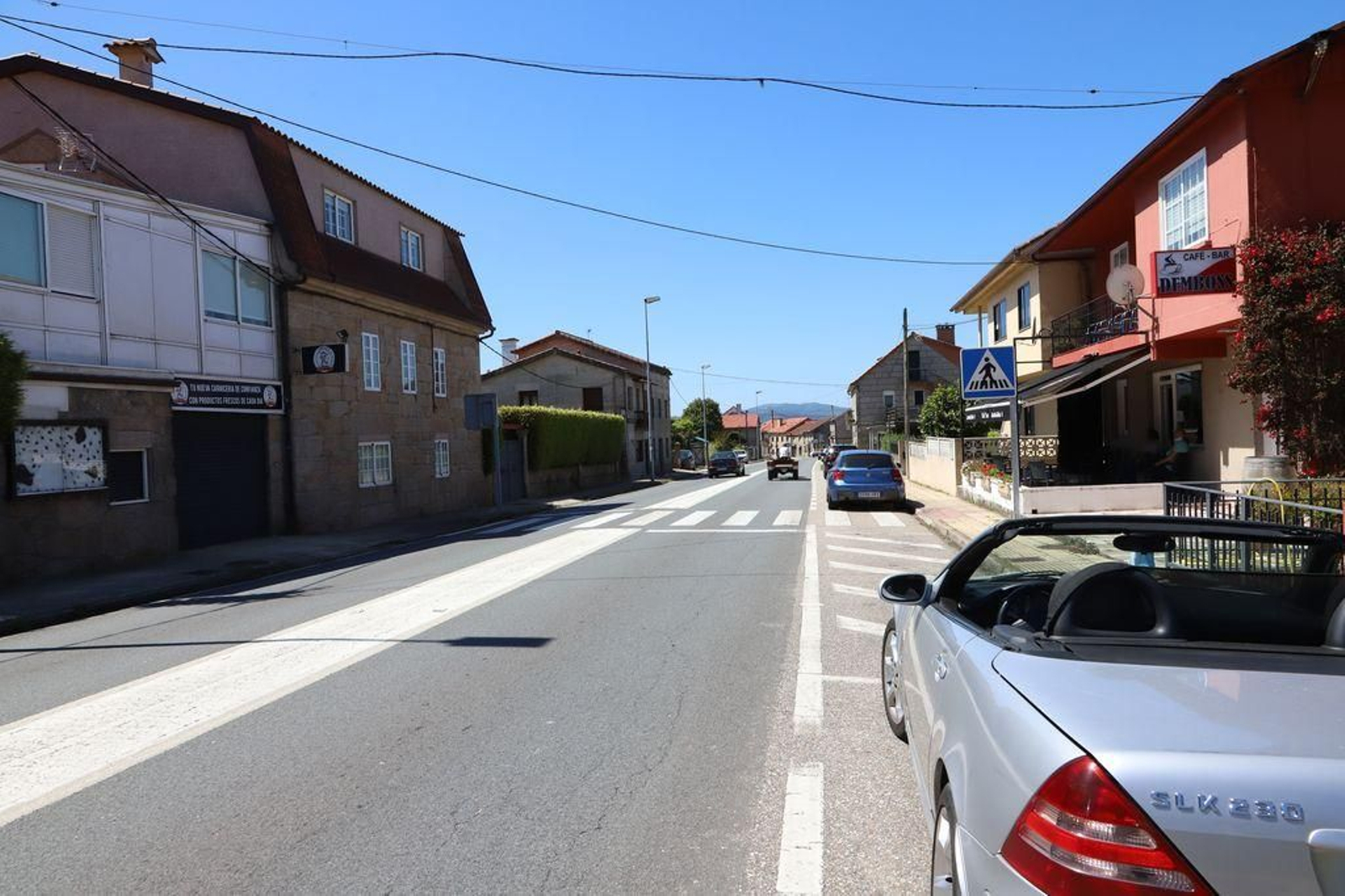 Un vehículo rebasa a un tractor en doble línea continua y en pleno centro urbano de Vincios.
