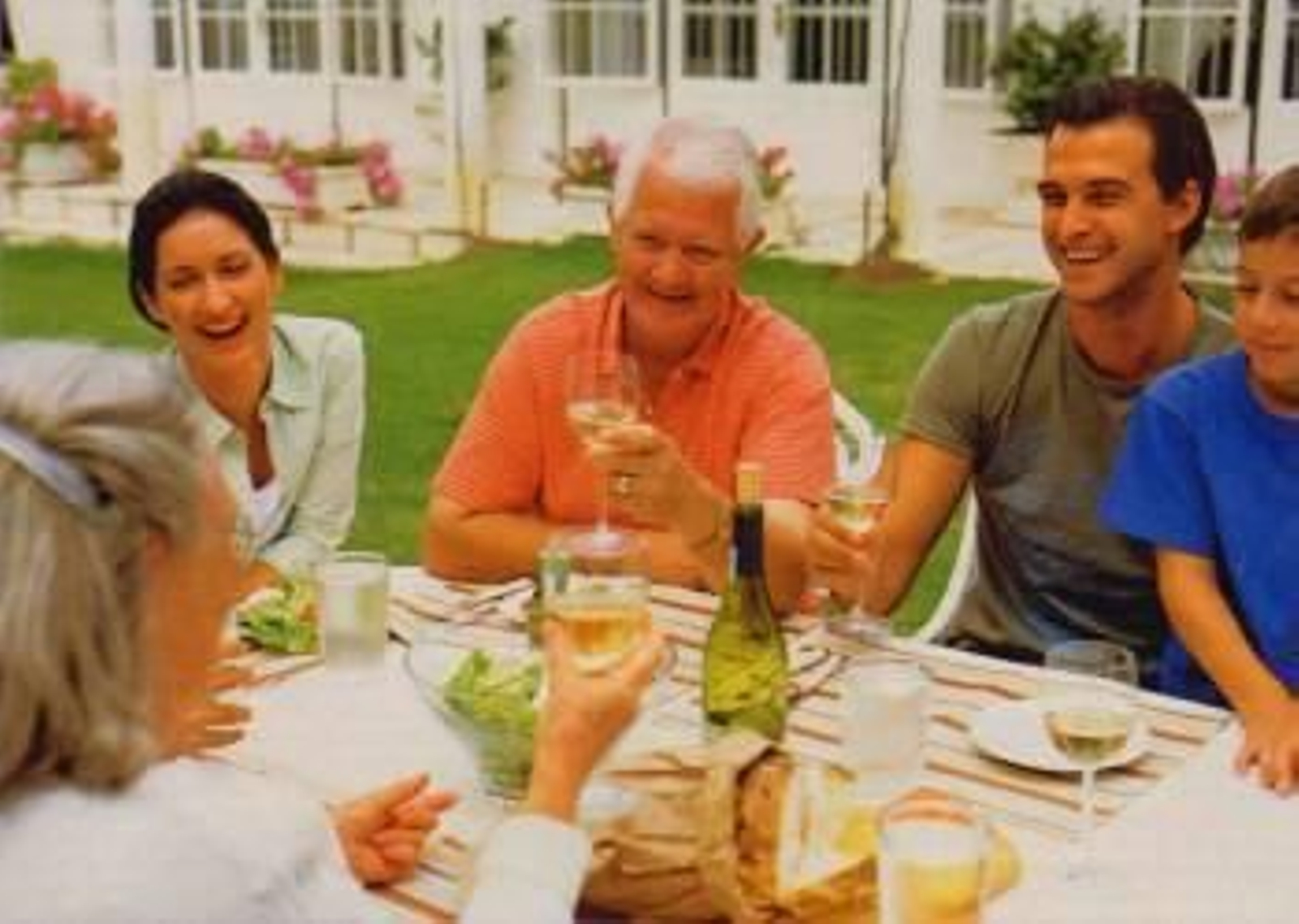 Una familia comiendo en el ardín de su casa.
