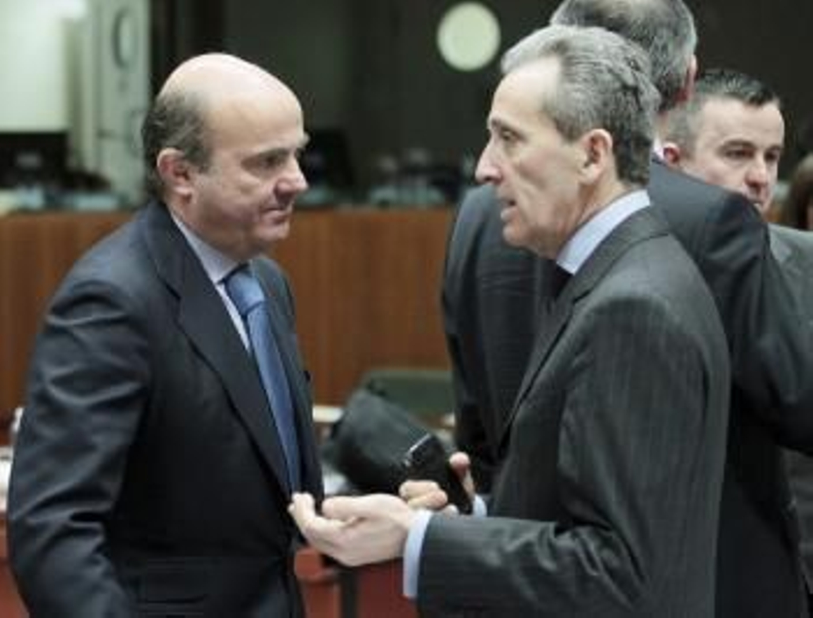 El ministro español de Economía, Luis de Guindos (izq), charla con el ministro italiano de Finanzas, Vittorio Grilli.