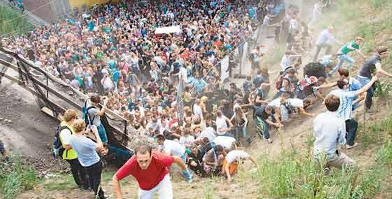 Revellers rush up a hill after panic broke out during the Loveparade in Duisburg, western Germany, on July 24, 2010. At least fifteen people were killed when a wave of panic swept through a Love Parade techno street party in the German city of Duisburg, north of Dusseldorf, police said.     TOPSHOTS     AFP PHOTO / ERIK WIFFERS  GERMANY OUT