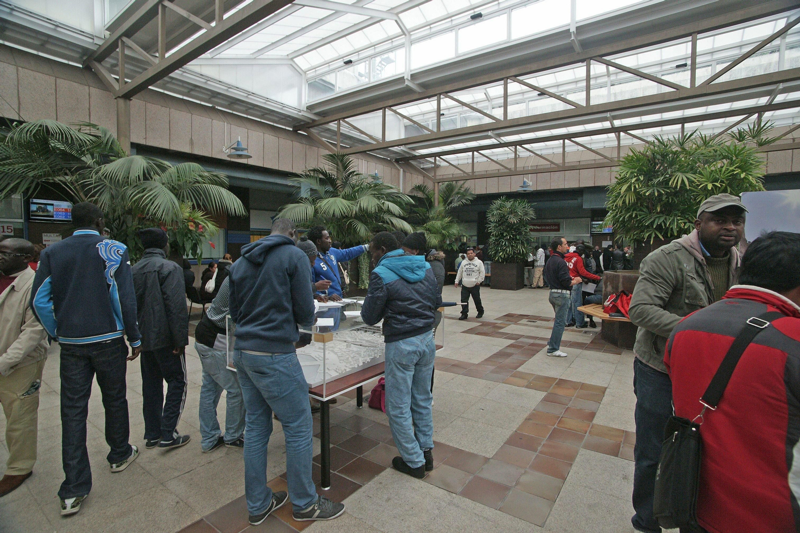 inmigrantes a la espera en la lonja del Concello, donde se encuentra la oficina del censo y padrón municipal.