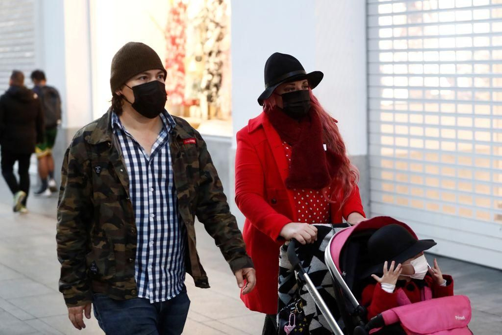 Una pareja pasea con su hijo pequeño.