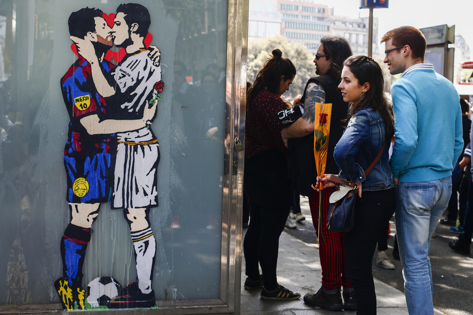 Una pareja, con la típica rosa, en una cola de Sant Jordi.