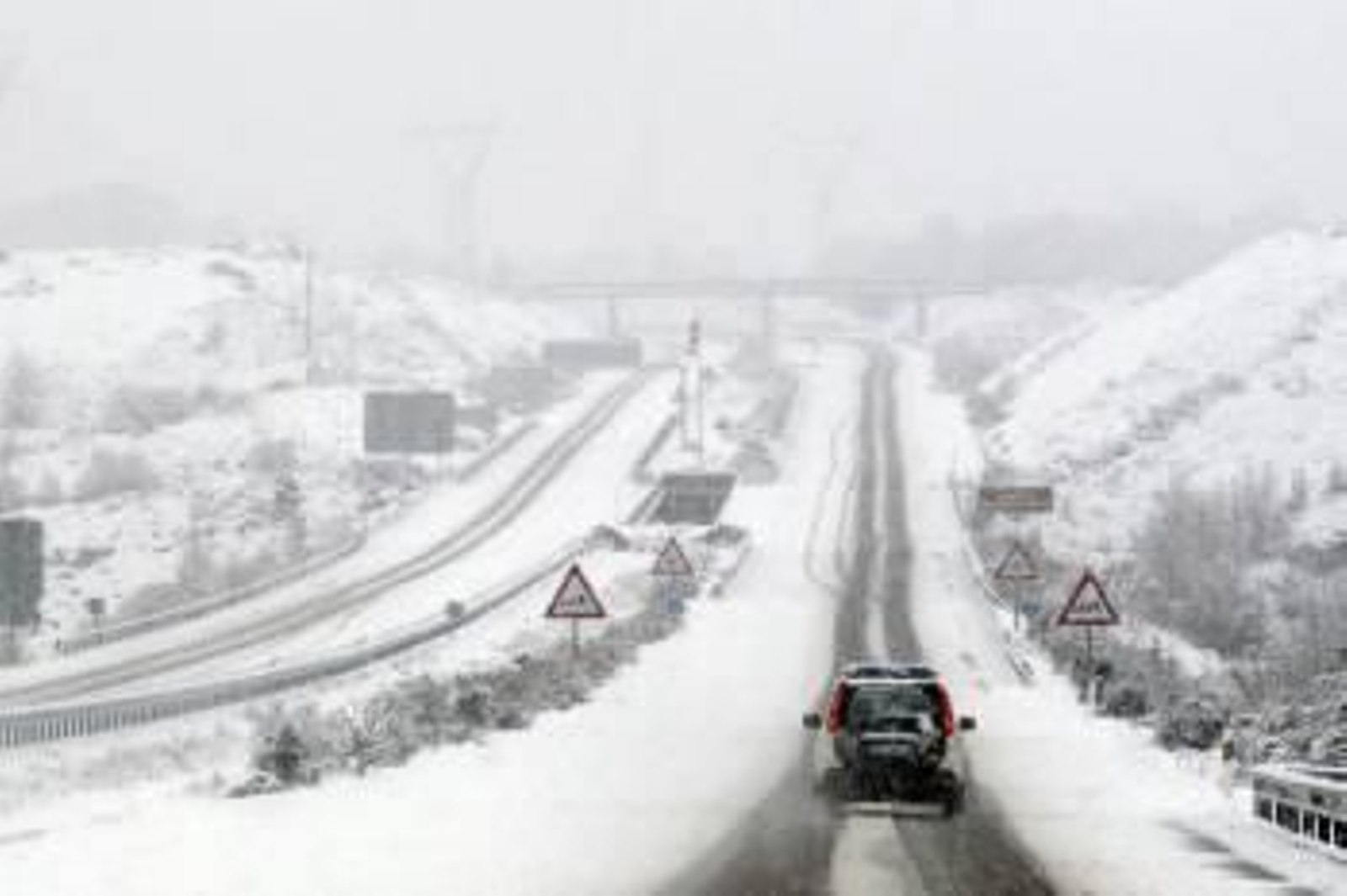 Un coche de la Guardia Civil circula por la autovía A-52 en el término municipal de Puebla de Sanabria (Zamora), en el momento en el que sólo estaba permitido circular con turismos debido a la nevada caída en la mañana de hoy.EFE