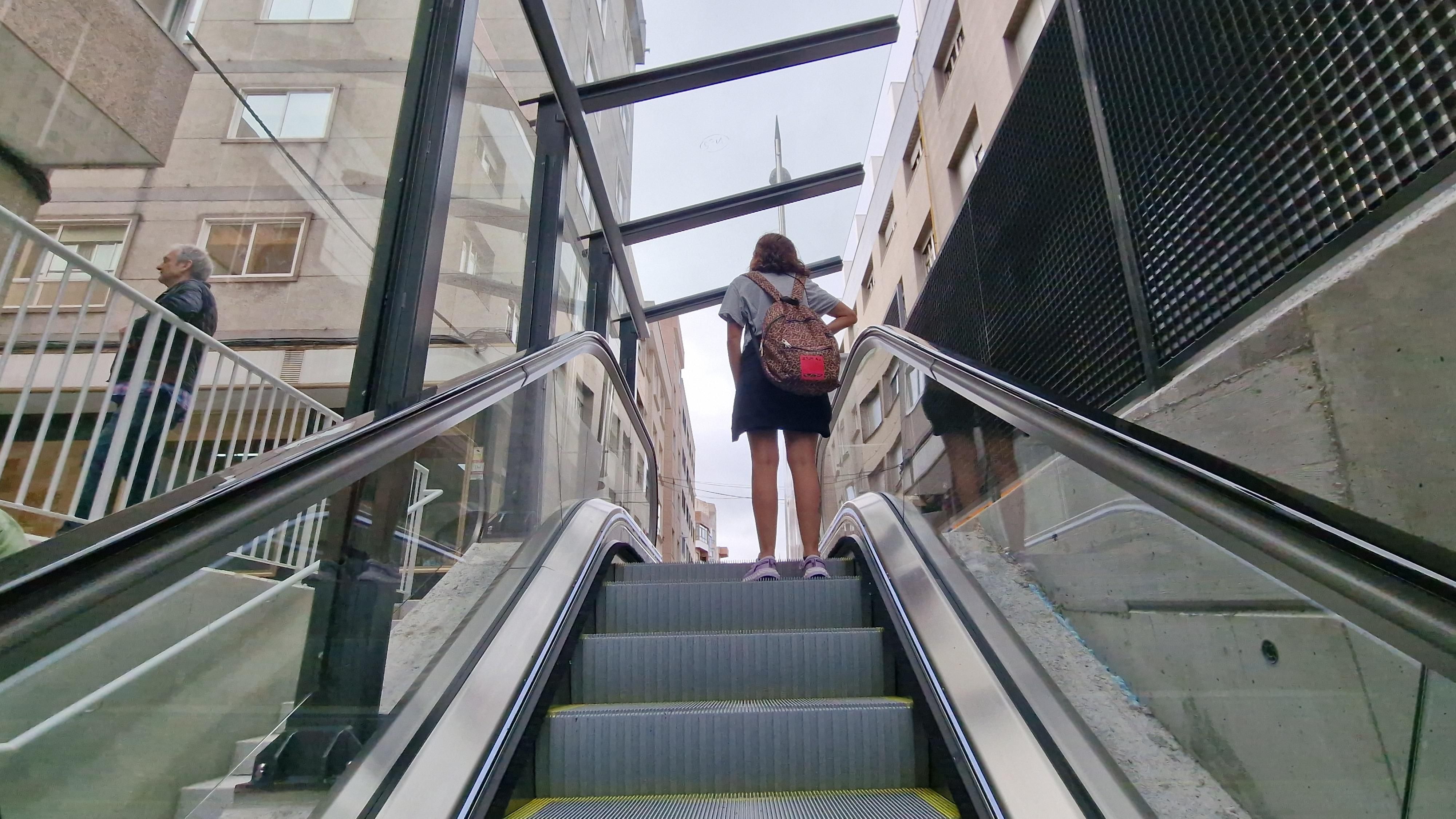 Un usuaria hace uso de las escaleras mecánicas de la calle Talude.
