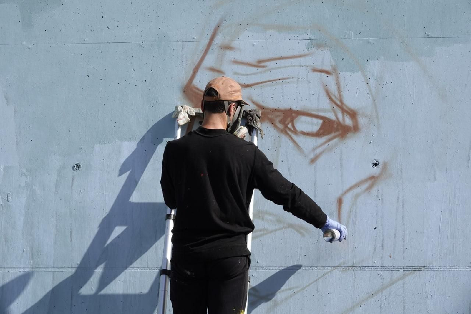 Un graffitero expresando su arte sobre un muro // Vicente Alonso