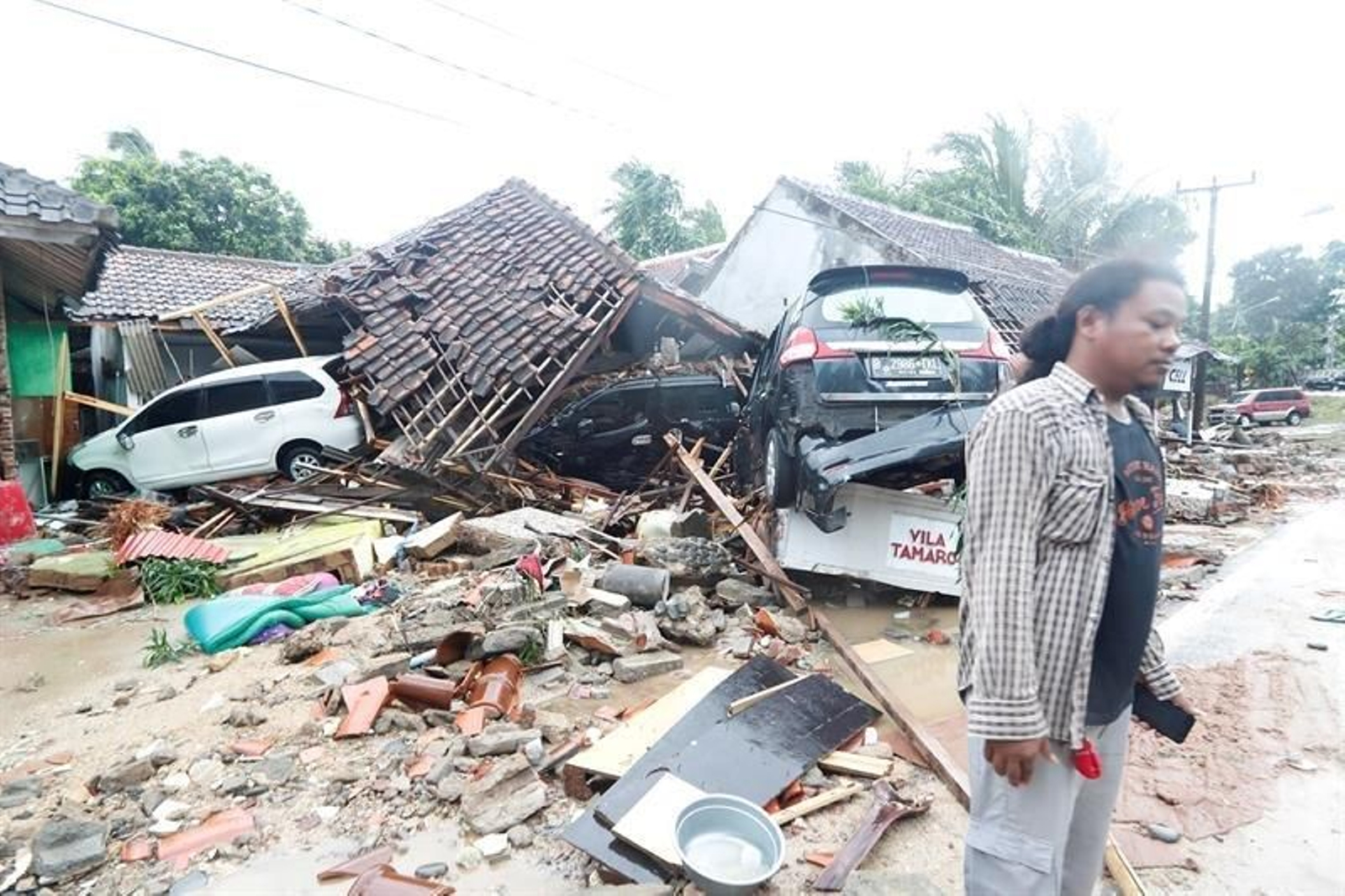 Un hombre está parado cerca de los escombros que quedan después de que un tsunami golpeó el Estrecho de Sunda en Pandeglang, Banten, Indonesia