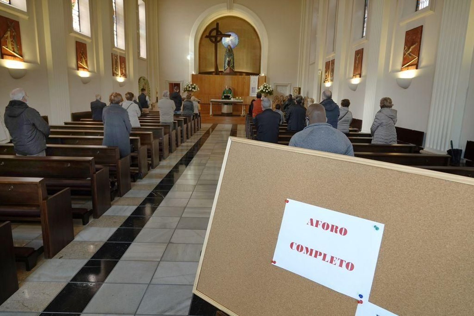 El cartel de aforo completo en la iglesia, ayer domingo, con sólo 25 personas.