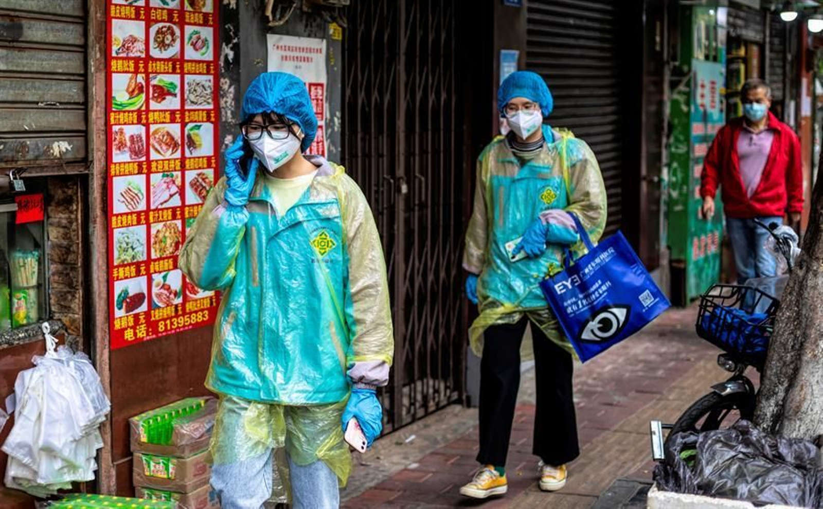 La gente camina en la calle con máscaras y otros equipos de protección.