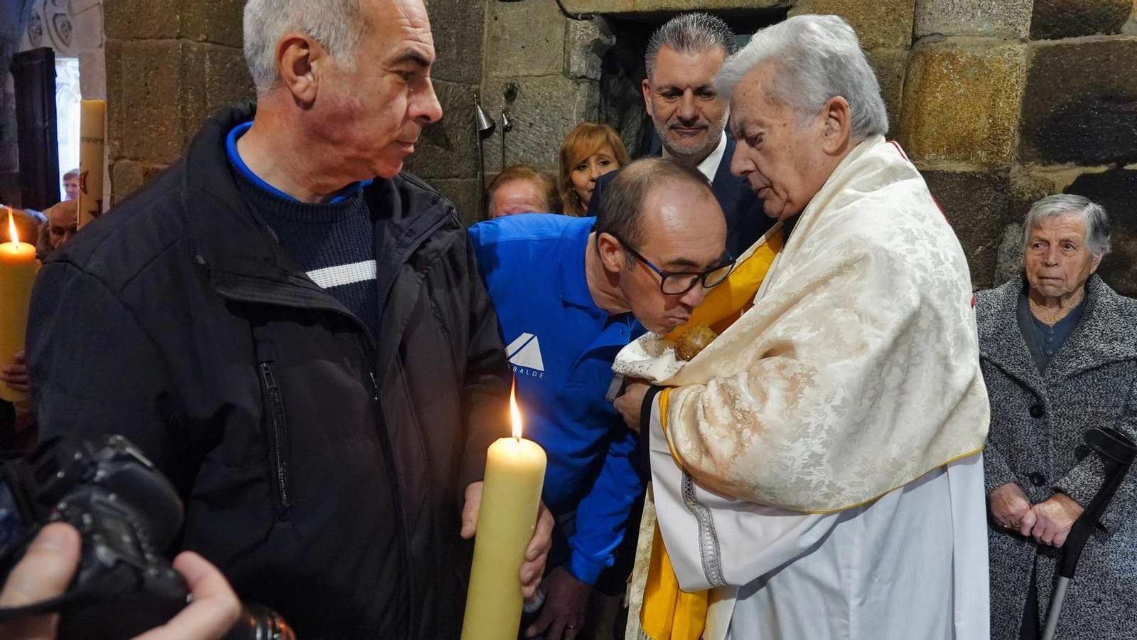 Un devoto besa una imagen en la romería de As Candelas en Castrelos.