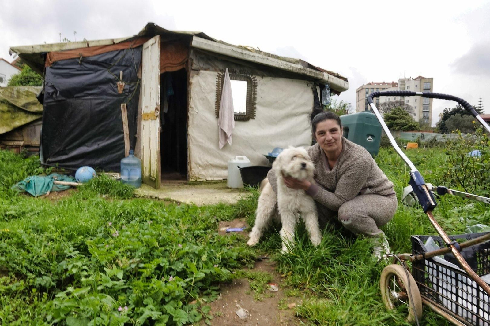 Carmen, con su perro, y ante su chabola en Santa Rita.