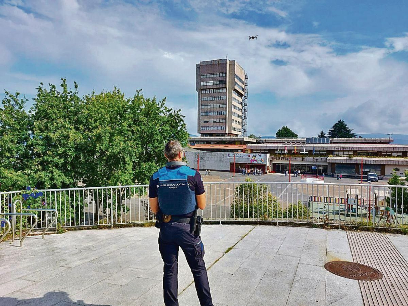 Un agente de la Policía Local volando un dron frente al edificio del Concello.