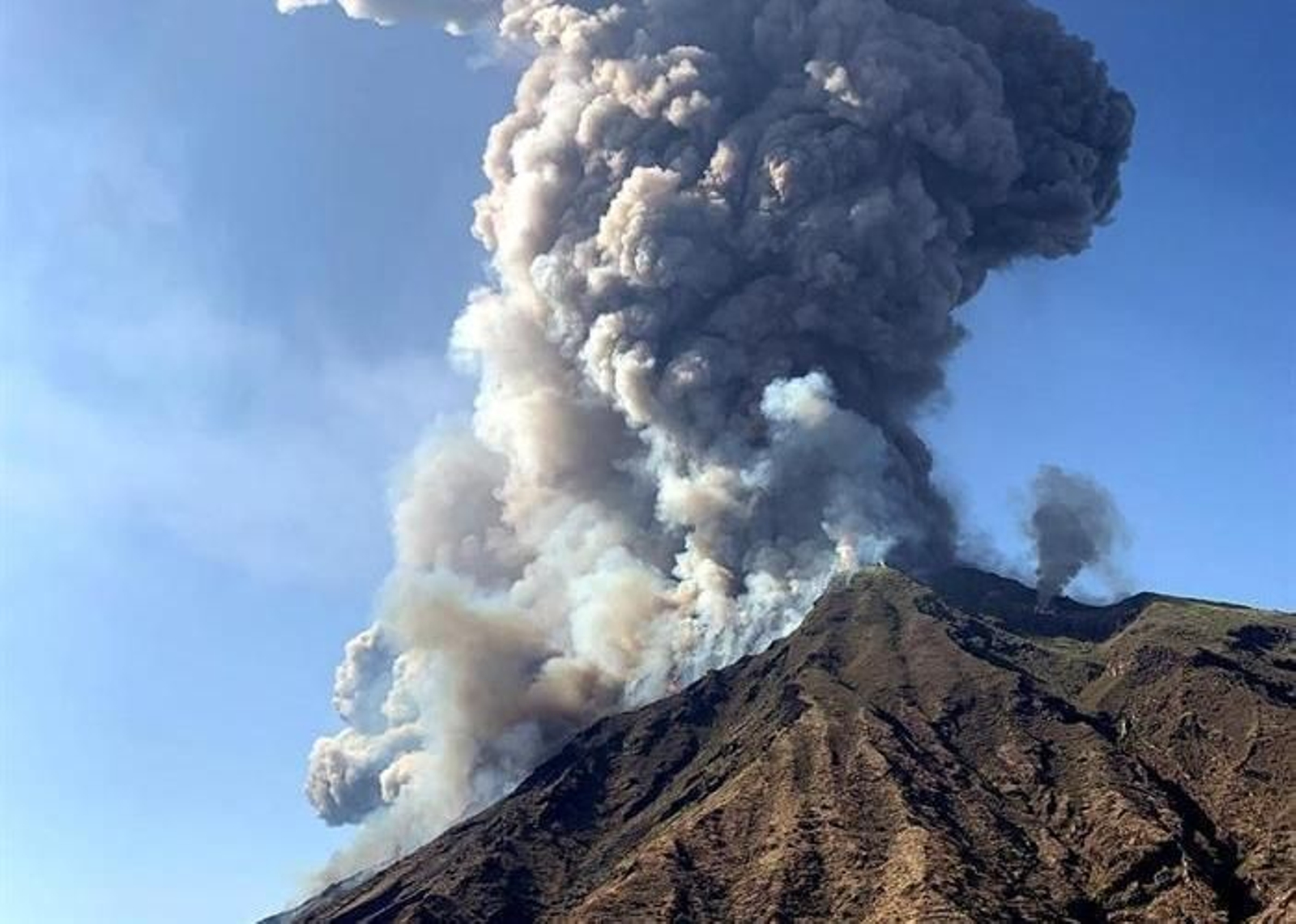 La ceniza se eleva hacia el cielo después de una erupción volcánica en una pequeña isla de Stromboli