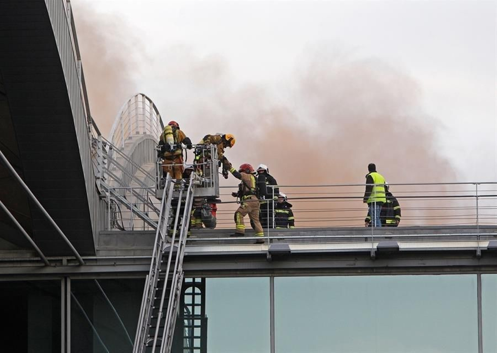 Un equipo de bomberos accede al techo del aeropuerto de Alicante-Elche para atajar el incendio en una de las cubiertas de la terminal de embarque