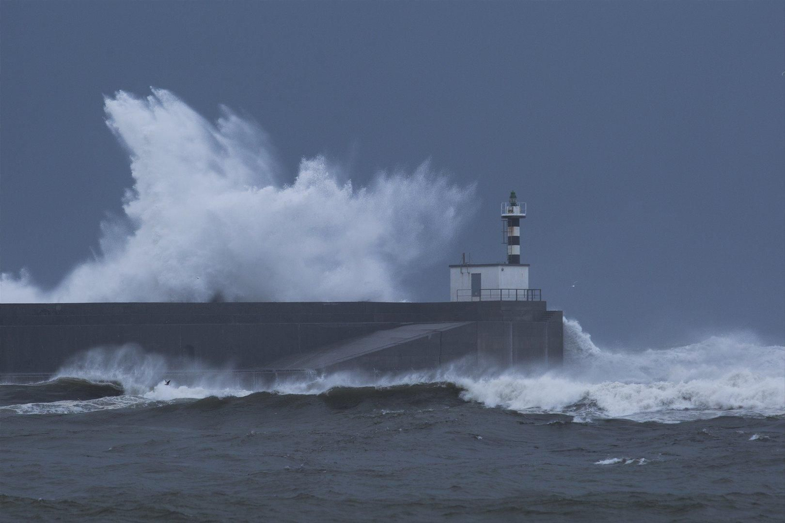 Olas rompen contra el faro de la localidad de San Esteban de Pravia. // EP