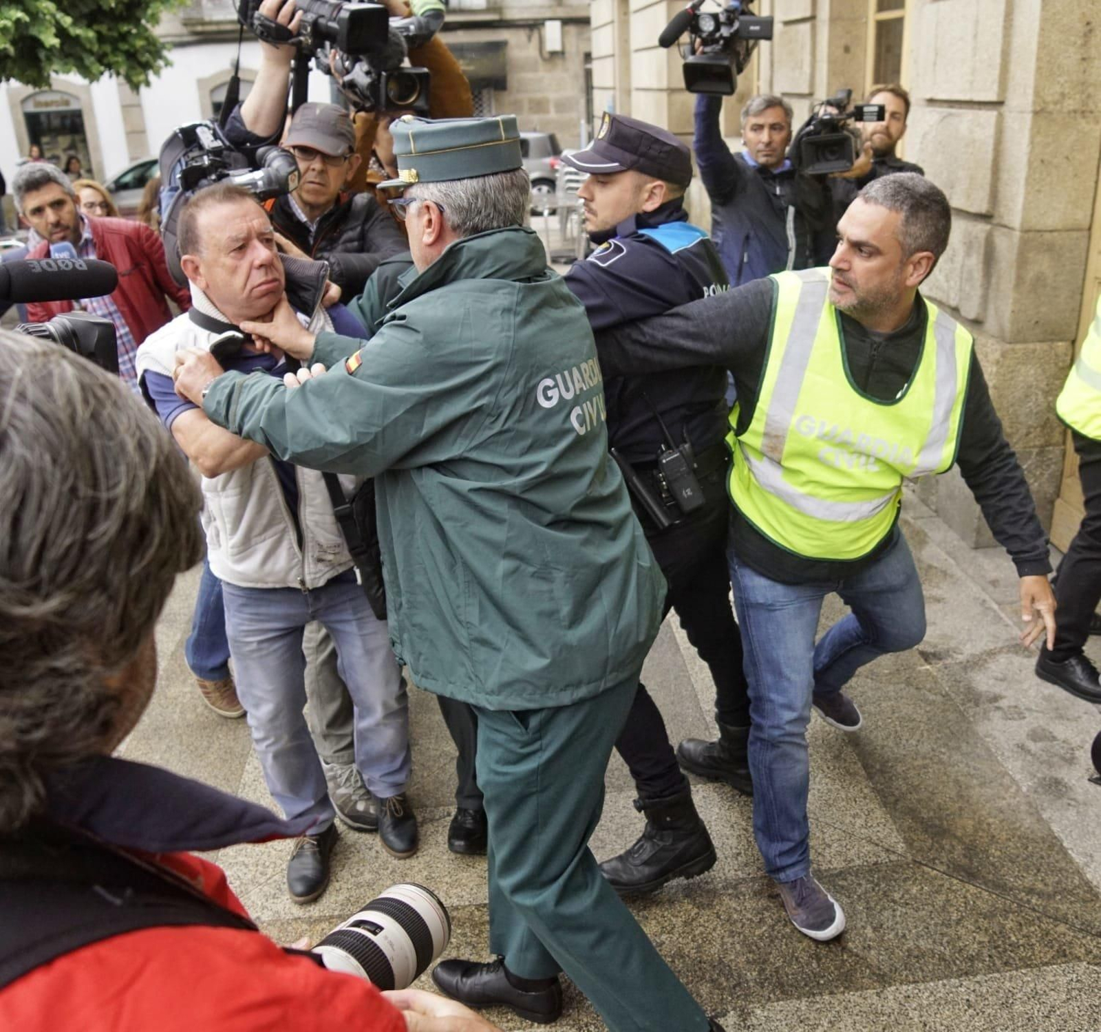 Un vecino intenta agredir al acusado a su llegada a los juzgados. // Vicente Alonso