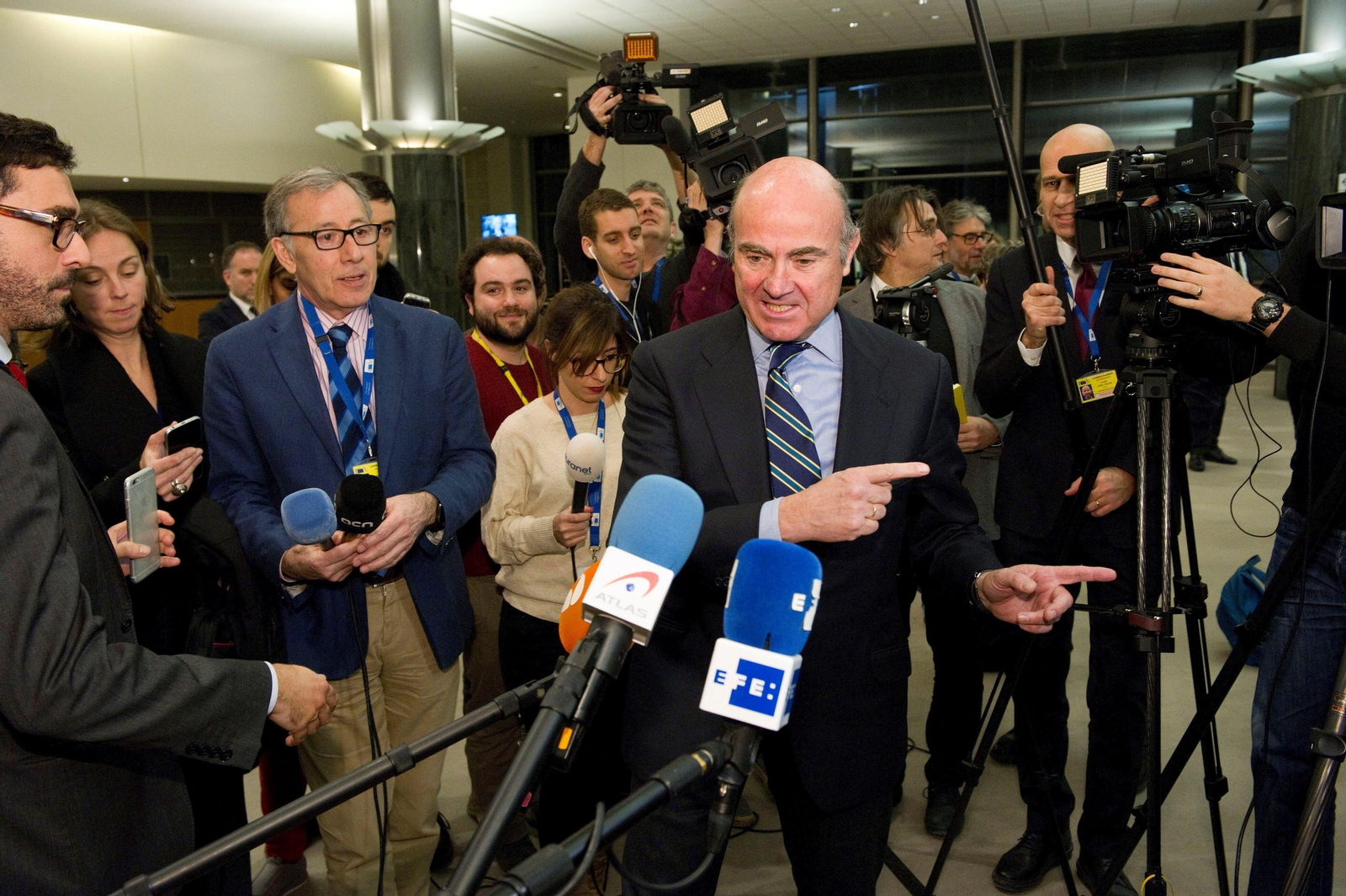 Luis de Guindos atiende a la prensa antes de comparecer en Bruselas.