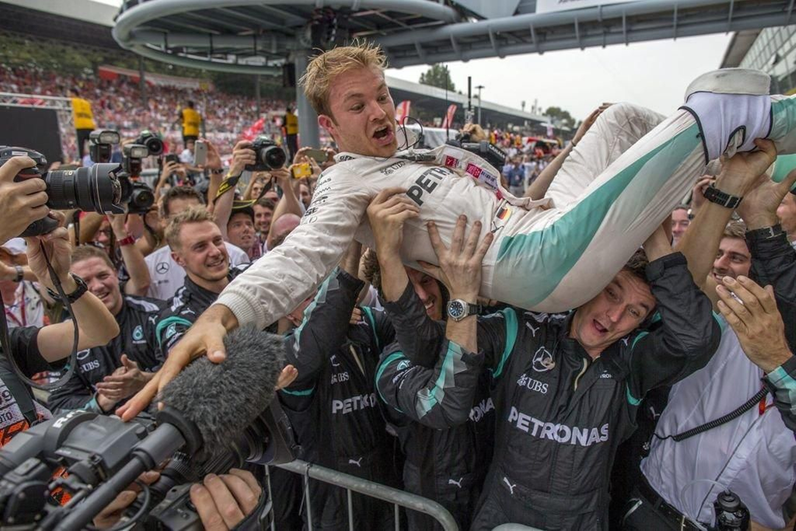 Nico Rosberg recibe la felicitación de sus compañeros de equipo tras la carrera disputada en Monza.