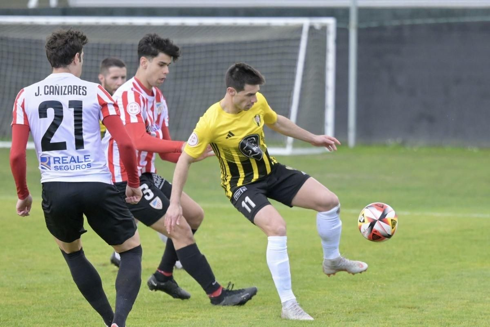 El rapidista Aitor Aspas protege la pelota ante el local Manu Rivas, que cuenta con la ayuda de Cañi.