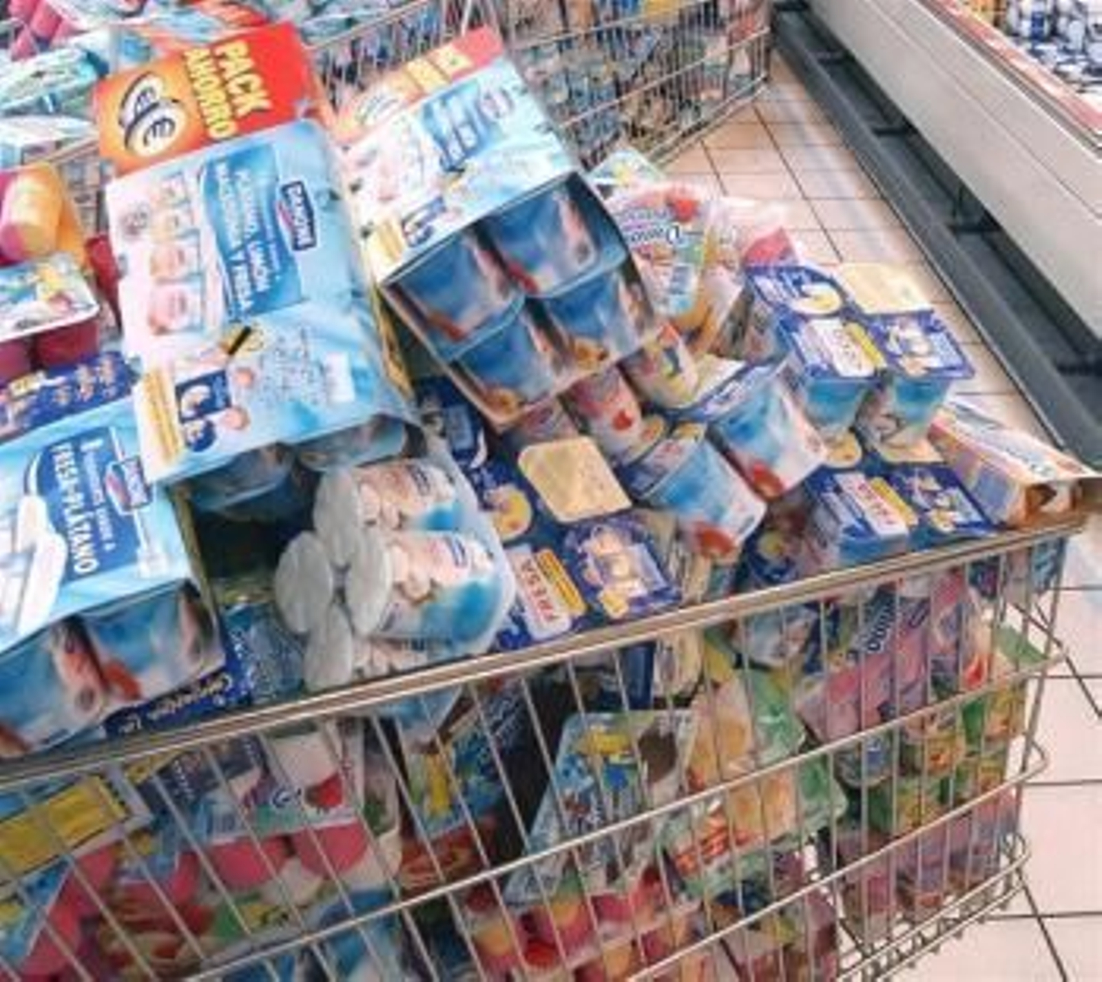 Un carro de compra lleno de productos de la marca Danone.