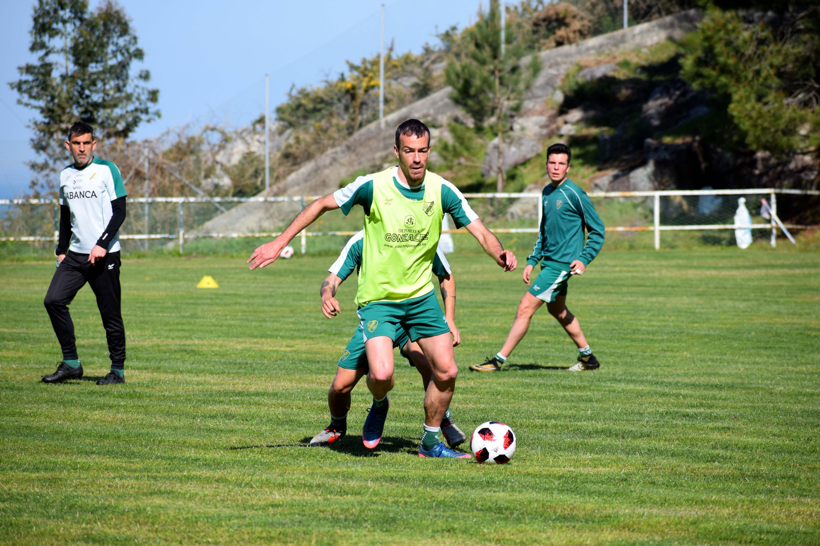Jacobo Montes sigue desde la distancia el entrenamiento del Coruxo en el que Yebra tiene el balón.