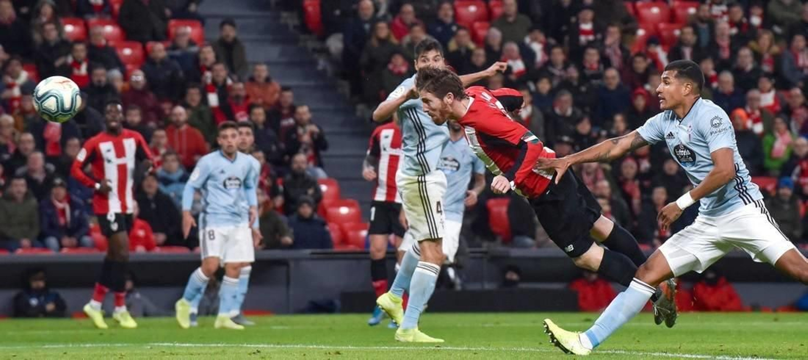 El delantero del Athletic Club Iker Muniain remata de cabeza junto al mexicano Néstor Araújo, del Celta de Vigo, durante el partido de la jornada 20 de LaLiga Santander disputado este domingo en San Mamés.