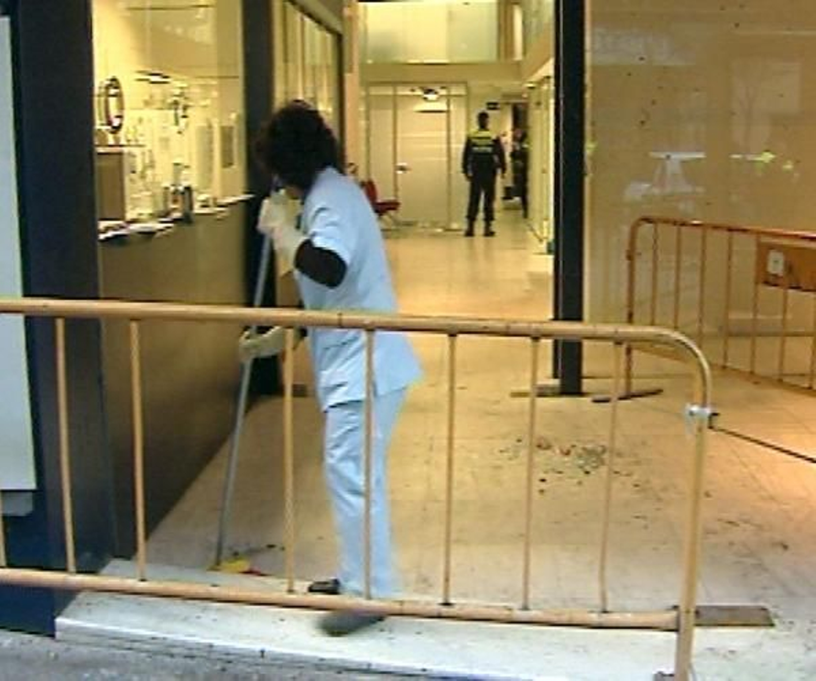 Imagen de televisión que muestra una mujer barriendo los restos de una cristalera. (Foto: EFE)