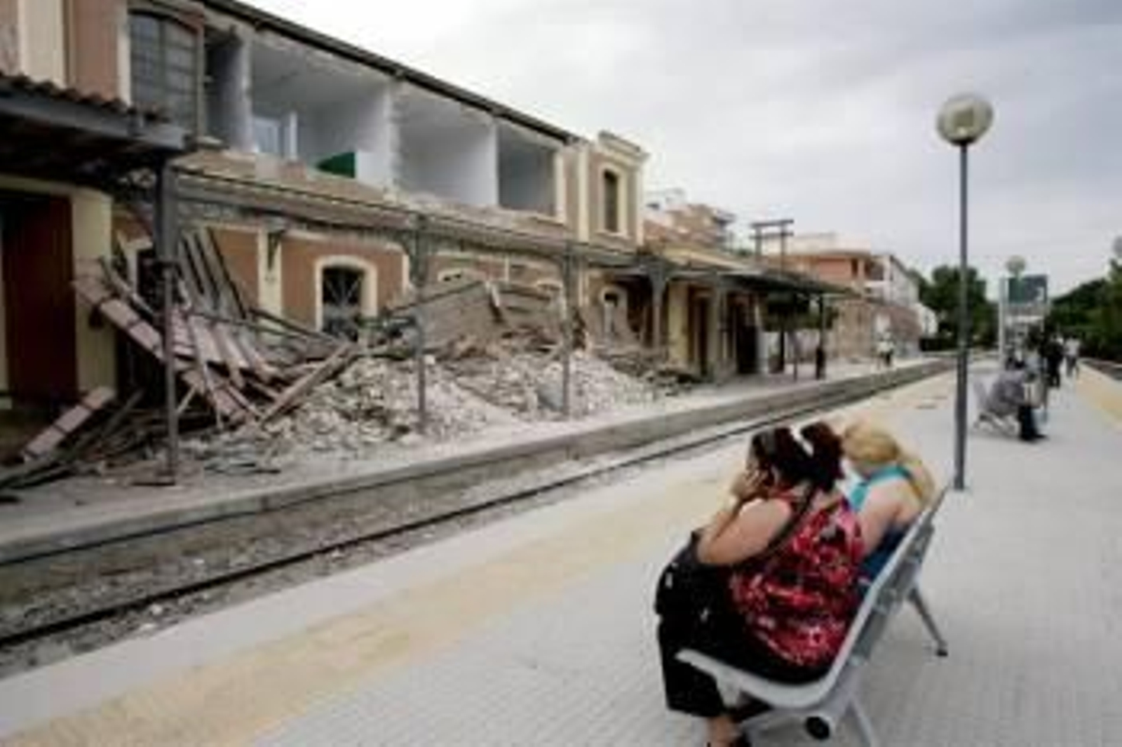 Varias personas esperan el tren de cercanías Murcia-Lorca en el andén de la estación de Sutullena, que resultó seriamente dañada a causa del terremoto. Foto: EFE