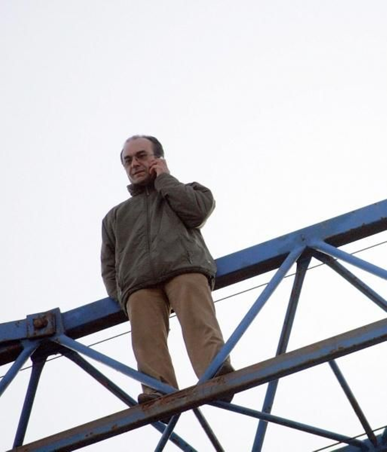 Vista del hombre subido en la grúa, hablando por el teléfono móvil. (Foto: Cabalar)