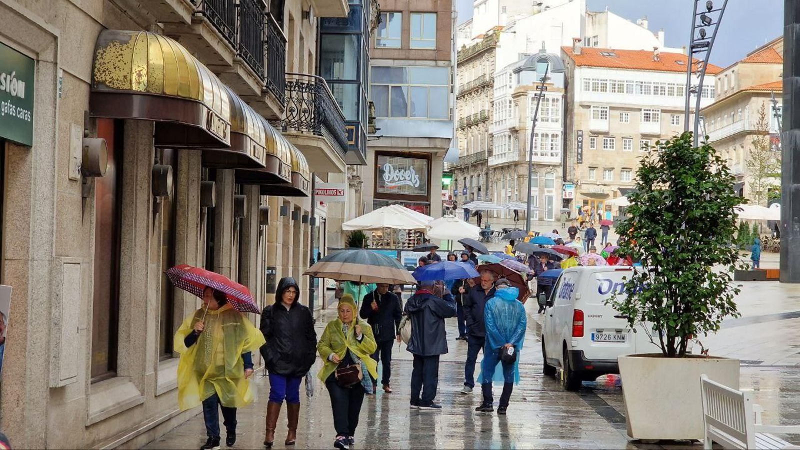 Gente con chubasqueros y paragüas en la Porta do Sol. // J.V. Landín