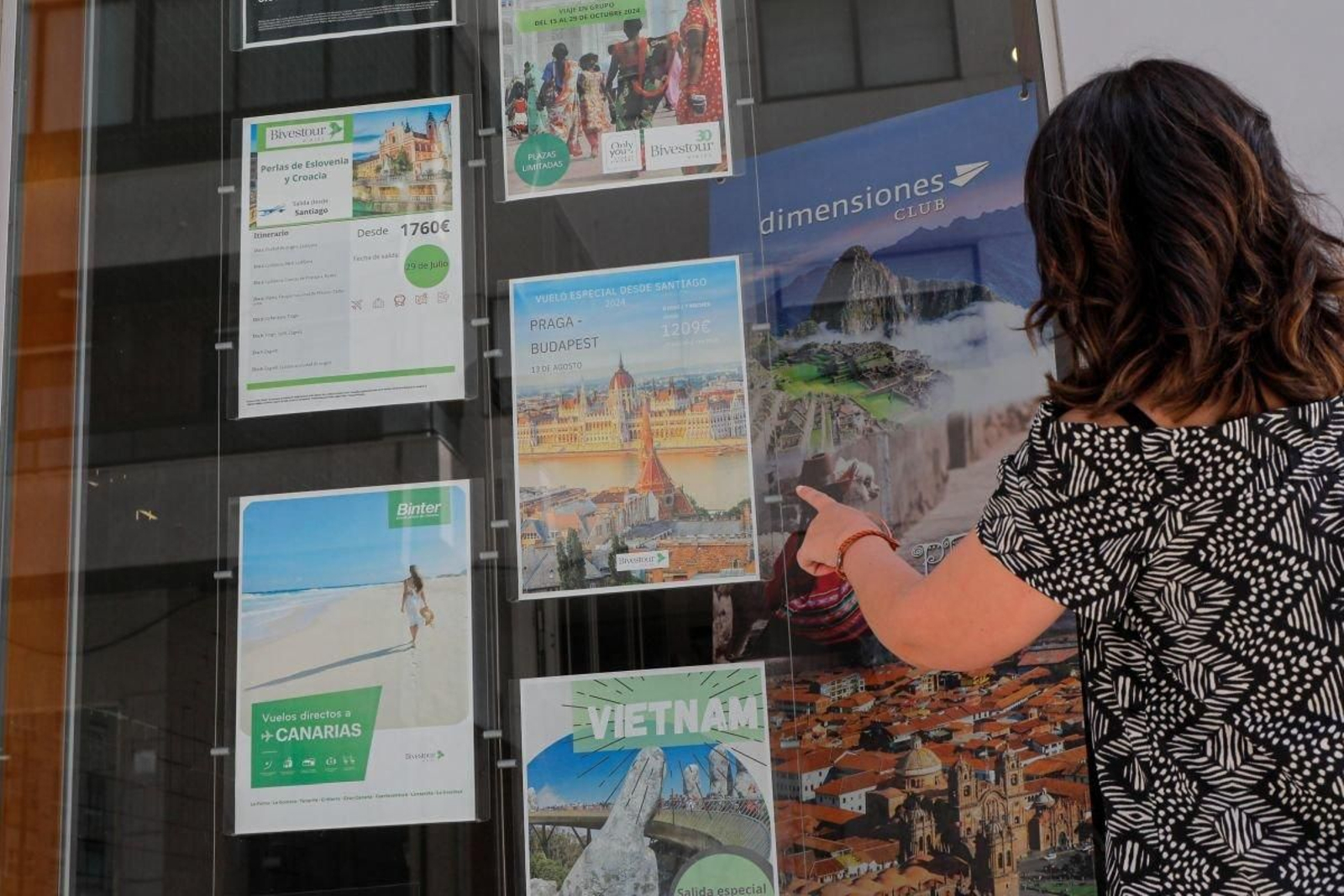 Promociones para el verano en un escaparate de una agencia de viajes de Vigo.