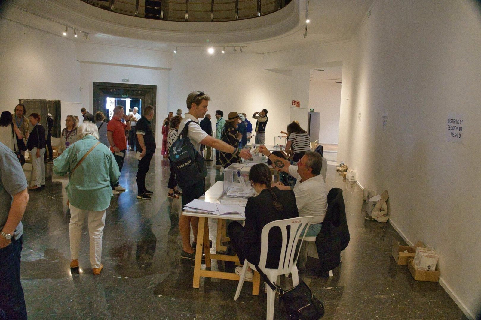 Un hombre recoge su DNI tras mostrarlo para poder votar.