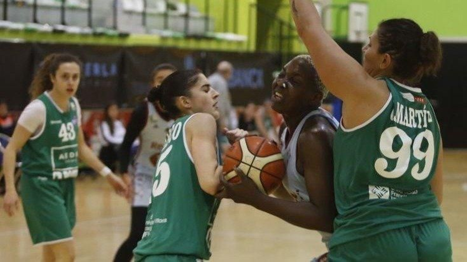 Elo Edeferioka lucha por un balón con dos jugadoras del Pozuelo ante la mirada de Paloma González (i).