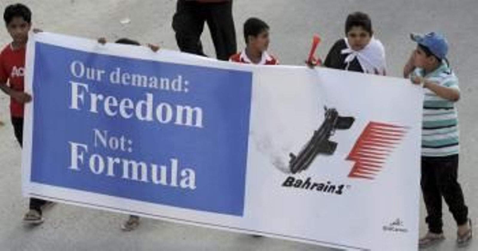 Niños muestran un cartel en protesta de la Fórmula 1, durante una marcha