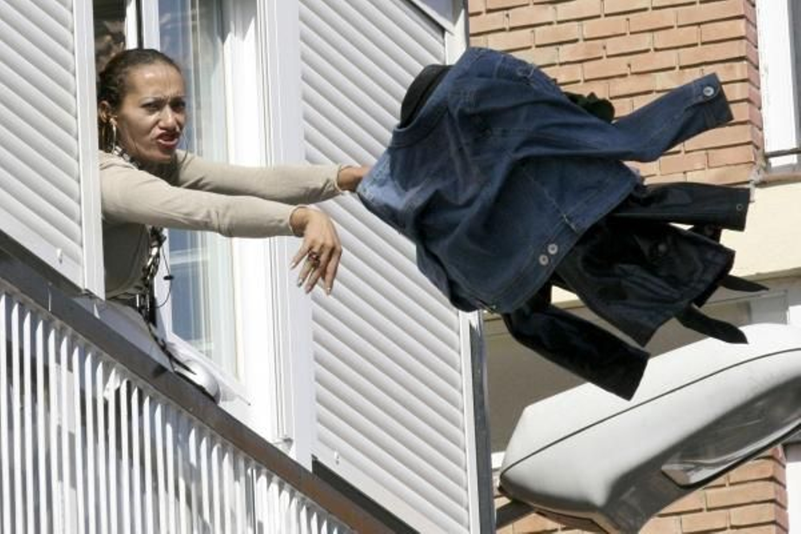Imagen de la agresora lanzando ropa desde una ventana. (Foto: Brágimo)