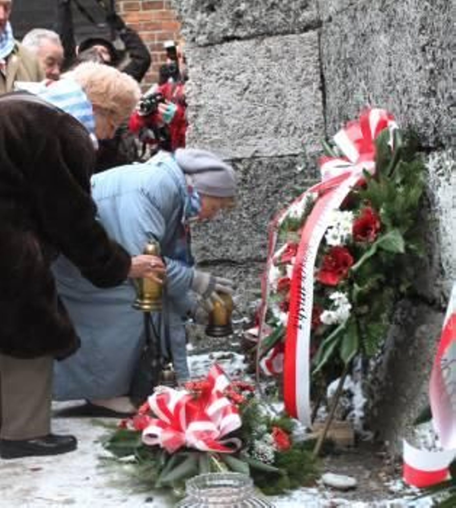 Exprisioneras del campo de concentración de Auschwitz depositan flores junto al 'Muro de la Muerte' en Oswiecim (Polonia)  (Foto: EFE)