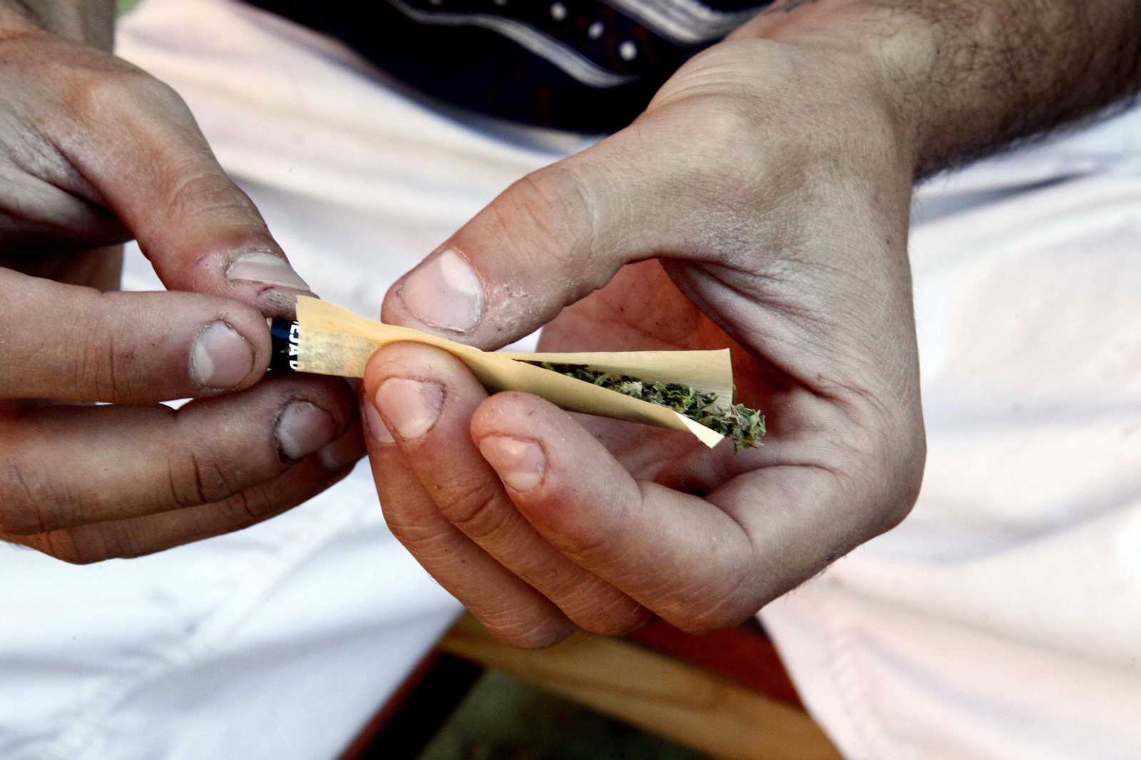 Una persona en el momento de liar un cigarro hecho con cannabis.