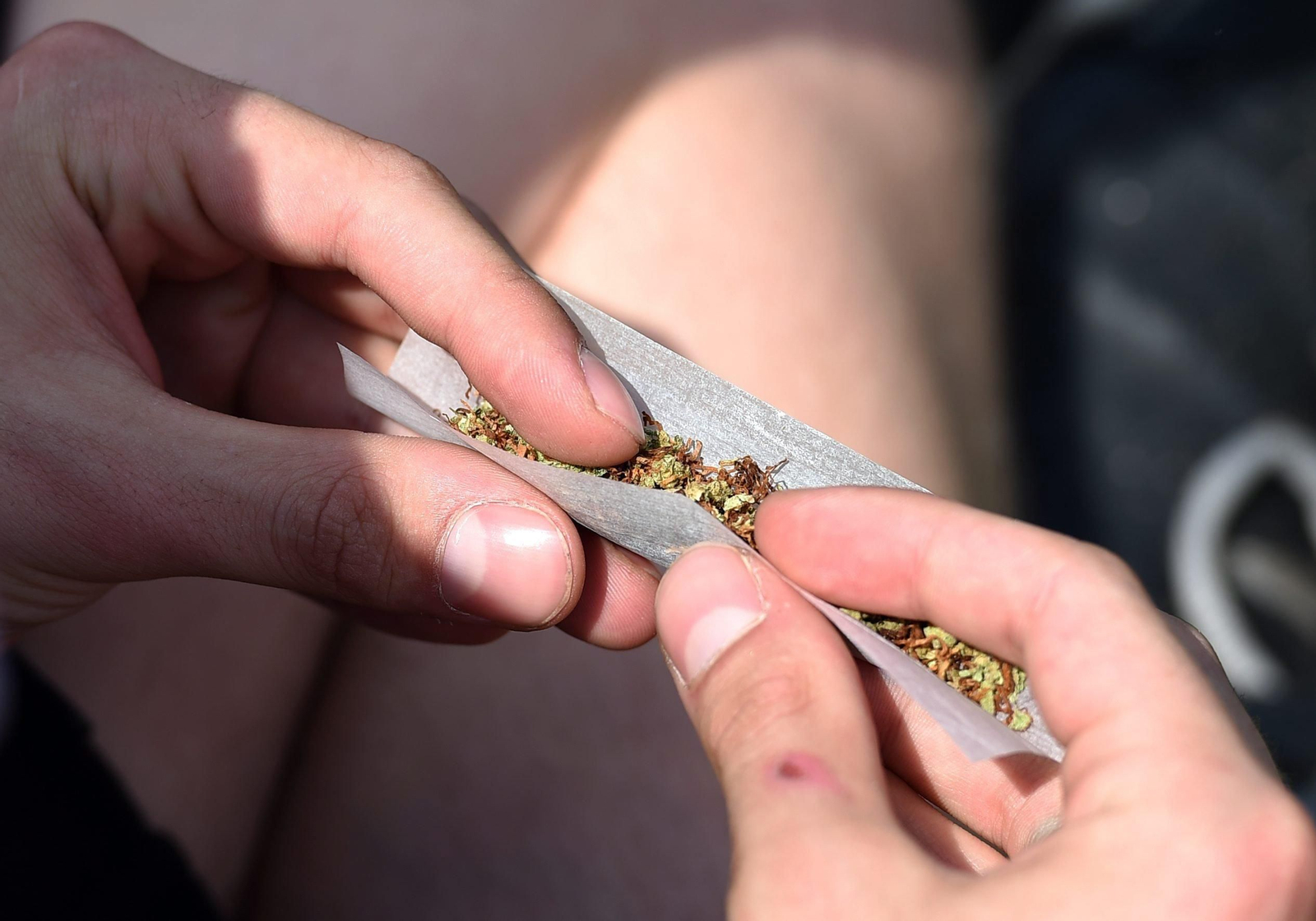 Un joven, en el momento de liar un cigarrillo de cannabis.