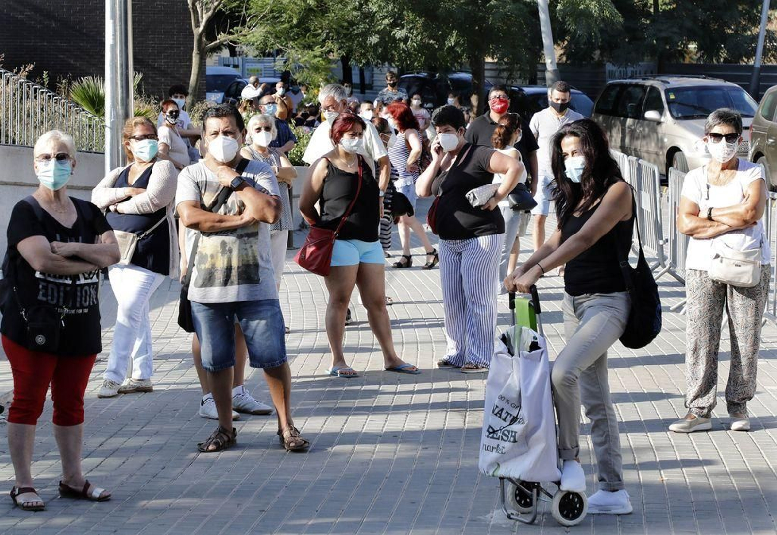 Vecinos del barrio barcelonés de Torre Baró hacen cola para someterse a los test de PCR voluntarios.